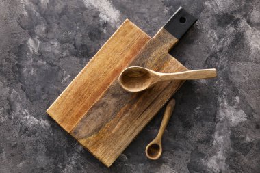 Tahta kesme tahtası ve siyah arka planda kaşıklar