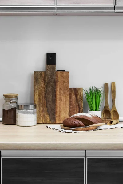 木料切割板 装有产品的罐子 勺子和家用植物放在靠近轻墙的桌子上 — 图库照片