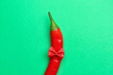 Yeşil arka planda acı biber ve makarna.