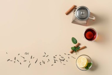 Çaydanlık ve bardağın karışımı, sarı arka planda lezzetli çay.