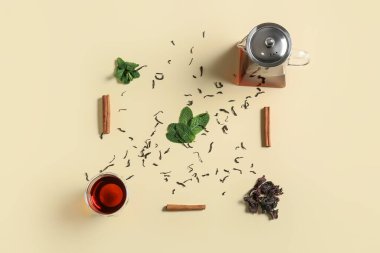 Çaydanlık ve bardağın karışımı, sarı arka planda lezzetli çay.