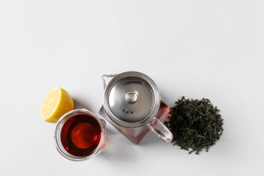 Çaydanlık ve bardaktan oluşan hafif arkaplanda lezzetli bir çay.