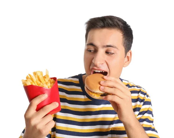 Junger Mann Mit Pommes Frites Isst Burger Auf Weißem Hintergrund — Stockfoto