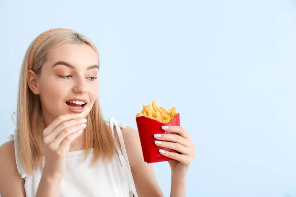 Jonge Vrouw Eten Franse Frietjes Blauwe Achtergrond — Stockfoto