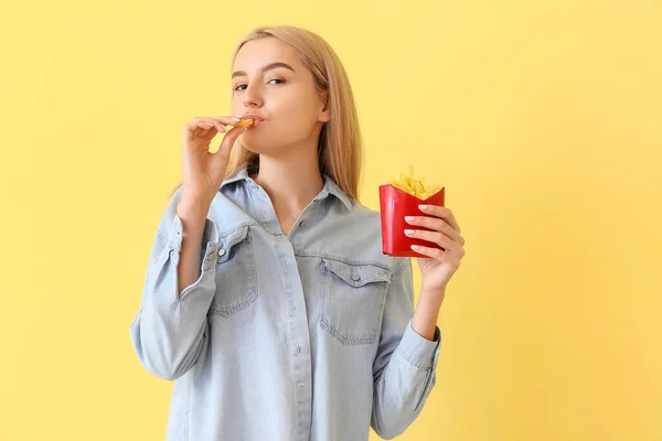 Jovem Mulher Comendo Batatas Fritas Fundo Amarelo — Fotografia de Stock