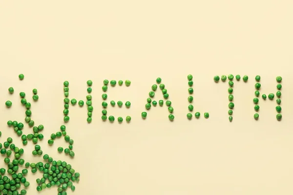 ベージュの背景に緑のエンドウ豆で作られた単語の健康 — ストック写真