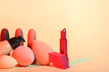 Renk arkaplanında makyaj süngeri ve kozmetik