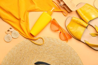 Plaj aksesuarları ve renkli arka planda bir şişe güneş kremi olan kompozisyon, yakın plan.