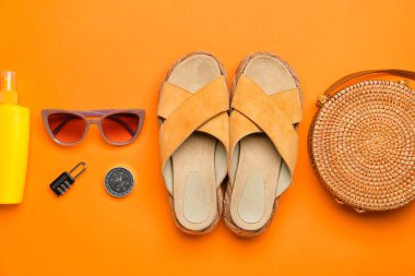 Kadın aksesuarları, seyahat malzemeleri ve renkli arka planda bir şişe güneş kremi ile kompozisyon