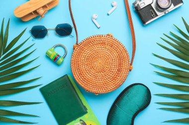 Renk arkaplan üzerinde şık çanta, aksesuarlar, belgeler ve palmiye yaprakları ile kompozisyon