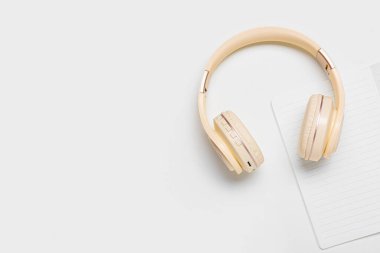 Beyaz arka planda modern kulaklıklar ve defter