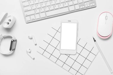 Beyaz arkaplanda cep telefonu, klavye ve modern aygıtlar ile kompozisyon