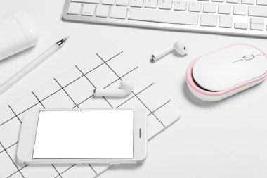 Cep telefonu, defter, kulaklık ve beyaz arkaplanda bilgisayar faresi, yakın plan