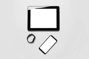 Tablet bilgisayar, cep telefonu ve beyaz arkaplanda fitness izleyici
