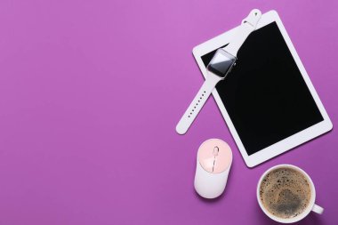 Tablet bilgisayar, akıllı saat, bilgisayar faresi ve renkli arka planda bir fincan kahve.