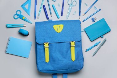 Okul çantası ve beyaz arkaplanda farklı kırtasiye malzemeleri
