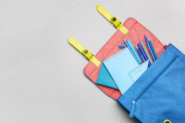 Beyaz arkaplanda kırtasiye malzemesi olan okul çantası