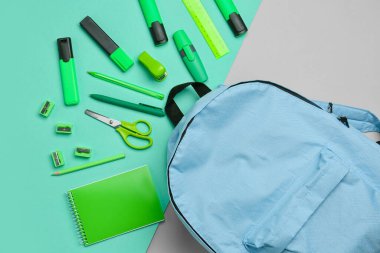 Renk arkaplan üzerinde sırt çantası olan farklı kırtasiye seti