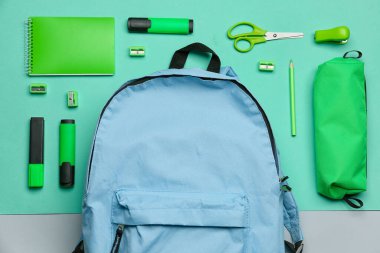 Renk arkaplan üzerinde sırt çantası olan farklı kırtasiye setleri, yakın plan