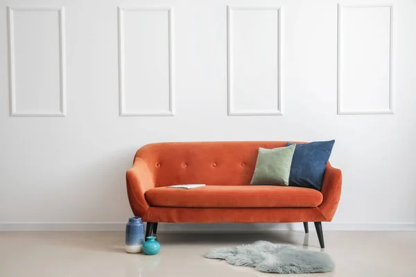 Stylowa Brązowa Sofa Poduszkami Wazonami Dywanem Przy Jasnej Ścianie — Zdjęcie stockowe