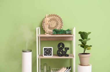 Renk duvarının yanında dekor ve nemlendirici ile kitap rafı