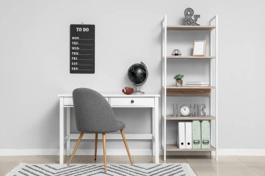 Gri duvarın yanında şık bir çalışma odası.