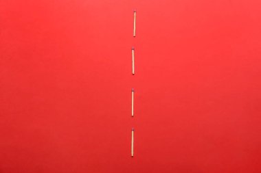 Kırmızı arka planda bir sürü kibrit çöpü var. Sosyal uzaklık kavramı