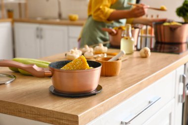 Mutfaktaki ahşap masada mısır koçanlı sos tavası.