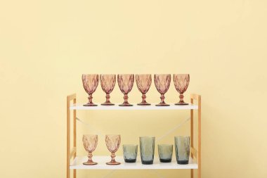 Renk duvarının yanındaki raf ünitesinde şık gözlükler.