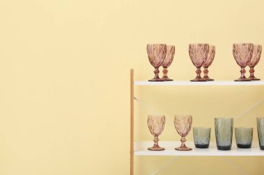 Renk duvarının yanındaki raf ünitesinde farklı gözlükler var.