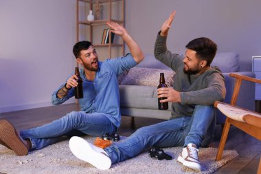 Bira şişeleri olan genç kardeşler akşamları birbirlerine beşlik çakıyorlar.