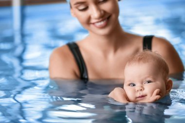 Yüzme havuzunda koçu olan şirin bir bebek, yakın plan.
