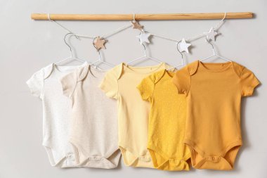 Işık duvarında asılı bebek kıyafetleri