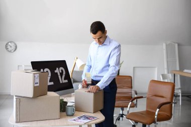 Genç adam taşınma gününde ofiste kaset çekiyor.