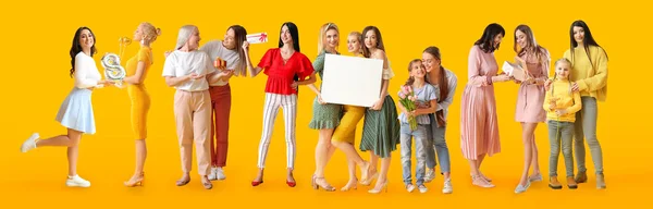 Sarı Arka Planda Hediyeleri Posterleri Olan Bir Grup Güzel Kadın — Stok fotoğraf