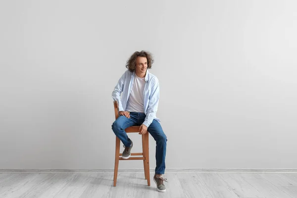 Fashionable Young Man Stylish Jeans Sitting Chair Light Wall — Stock Photo, Image