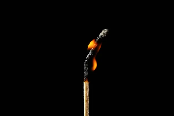 Burning matchstick on black background. Emotional burnout concept