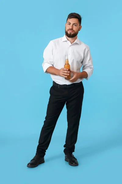 青い背景に淡いビールのボトルを持つ若いビジネスマン — ストック写真