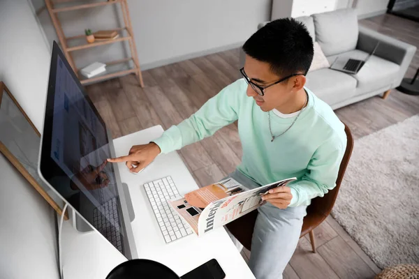 Jeune Homme Avec Magazine Pointant Vers Écran Ordinateur Maison — Photo