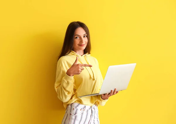 Hübsche Junge Frau Zeigt Auf Laptop Auf Gelbem Hintergrund — Stockfoto