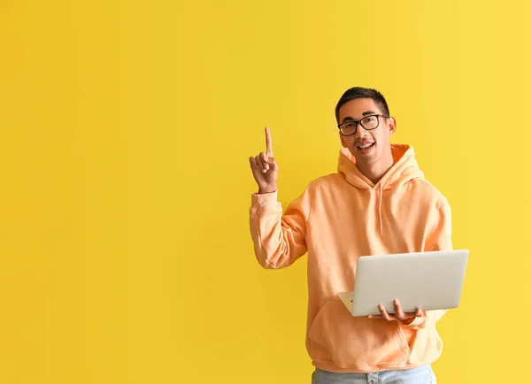 Красивий Молодий Чоловік Окулярах Ноутбуком Вказує Щось Жовтому Тлі — стокове фото