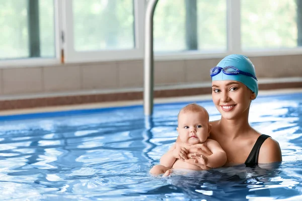 游泳教练和可爱的小宝宝在游泳池里 — 图库照片