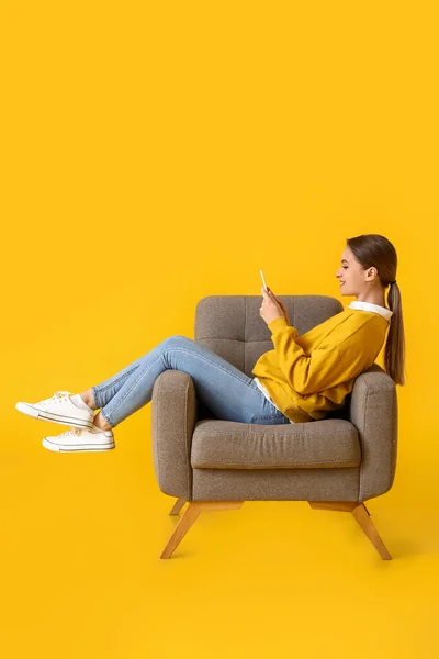 Pretty Young Woman Using Tablet Computer Soft Armchair Yellow Background — Stock Photo, Image