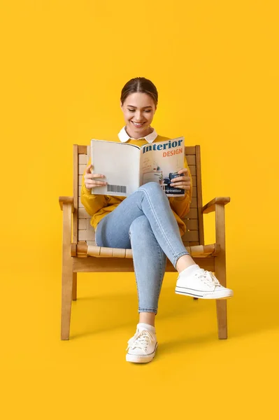 Hermosa Mujer Leyendo Revista Sillón Madera Sobre Fondo Amarillo — Foto de Stock