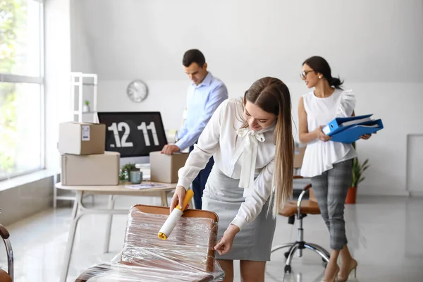 Jeune Femme Enveloppant Chaise Avec Film Étirable Dans Bureau Jour — Photo