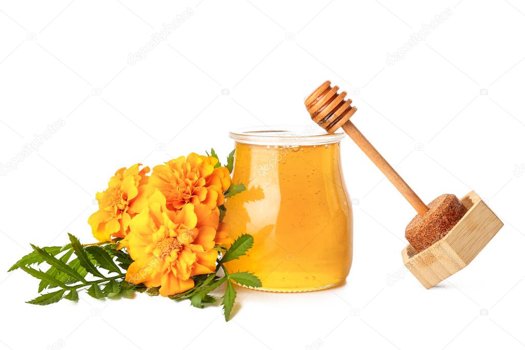 Opened jar with honey, dipper and marigold flowers on white background