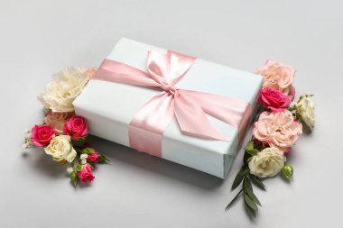 Çiçeklerle ve açık arkaplanda hediye kutusuyla güzel bir bahar kompozisyonu