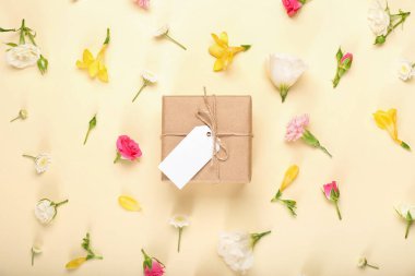Çiçekli güzel bahar kompozisyonu, boş etiket ve sarı arka planda hediye kutusu