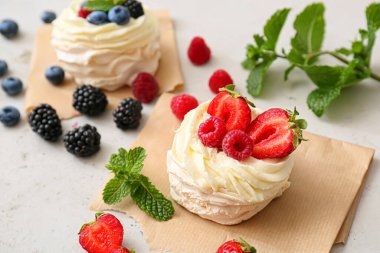 Hafif arkaplanda taze böğürtlenli lezzetli Pavlova kekleri