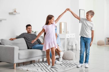 Mutlu çift ve evde dans eden çocukları